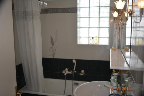 a bathroom with a tub and a sink and a window at ELENI'S VILLAGE RELAXATION HOME in Edipsos