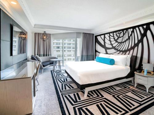 a hotel room with a bed and a desk at Pullman Cairns International in Cairns