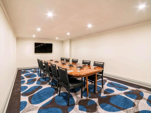 a conference room with a table and chairs on a rug at Pullman Cairns International in Cairns