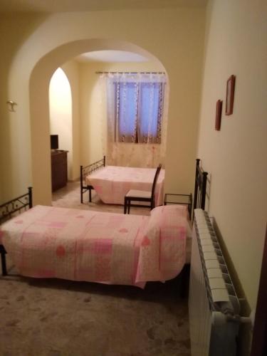 a bedroom with two beds and an arched doorway at Villa RosaMaria in San Chirico Raparo