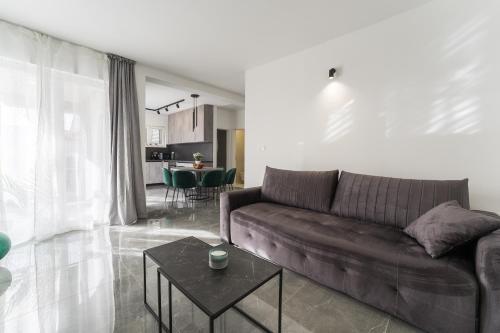 uma sala de estar com um sofá e uma mesa em Luxury D Apartments em Bibinje