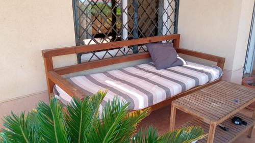 a wooden bed and a bench in a room at Habitaciones Jacaranda in Aguadulce