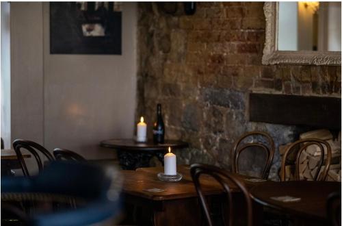 a dining room with a table with candles and a brick wall at Room at the Inn in Lyme Regis