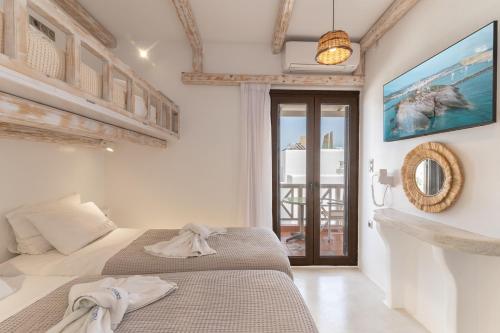 a bedroom with two beds and a view of the ocean at Nikos Apartments and Studios in Agios Prokopios