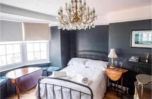 a bedroom with a bed and a chandelier at Room at the Inn in Lyme Regis
