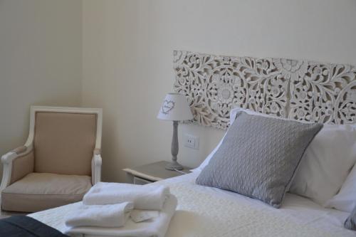 a bedroom with a white bed with a chair and a mirror at Affittacamere Casa Dane' in La Spezia