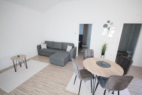 a living room with a couch and a table and chairs at Apartman Echo in Tuzla