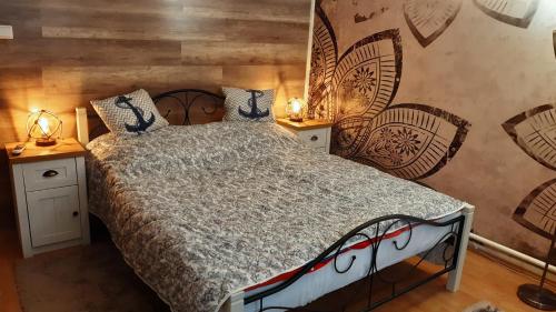 1 dormitorio con 1 cama grande y pared de madera en Haven Katherina en Fonyód