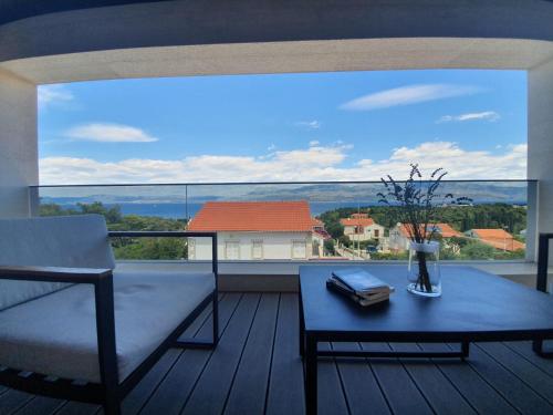 a living room with a couch and a table on a balcony at House G in Supetar