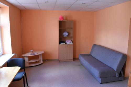 a waiting room with a blue couch and a table at Ukstiņa ielas apartamenti in Liepāja