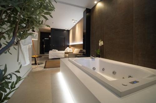 ein Bad mit einer großen weißen Badewanne in einem Zimmer in der Unterkunft Hotel Barrameda in Sanlúcar de Barrameda