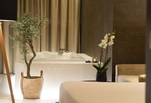 a bathroom with a sink and two vases with flowers at Hotel Barrameda in Sanlúcar de Barrameda