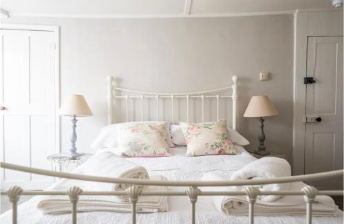 a white bed in a white bedroom with two lamps at Room at the Inn in Lyme Regis