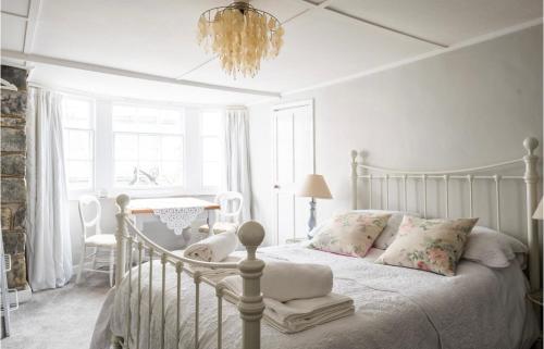 a bedroom with a white bed and a chandelier at Room at the Inn in Lyme Regis