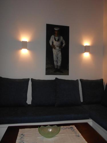a living room with a couch and a picture of a baseball player at Kalliope sea view summer house in Tripití