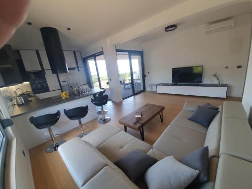 a living room with a white couch and a table at House G in Supetar