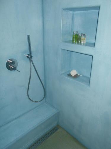 a blue bathroom with a shower with a shower at Kalliope sea view summer house in Tripití