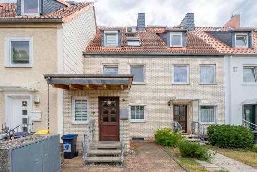 une maison en briques avec une porte rouge dans l'établissement Private Room, à Hanovre