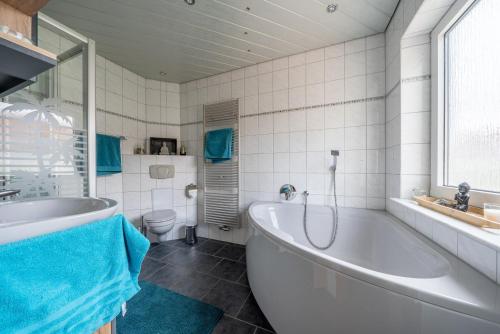 a white bathroom with a tub and a toilet at Private Room in Hannover