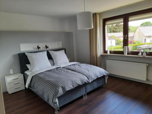 a white bedroom with a bed and a window at Ferienwohnung Müller in Duderstadt