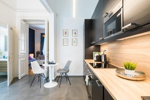 a kitchen with a counter with chairs and a table at Double Blue Apartment in Budapest Downtown in Budapest