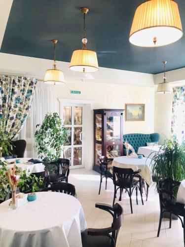 a dining room with tables and chairs and lights at Churchill-Inn in Vinnytsya