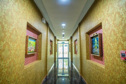 a hallway of a building with a door and paintings at Siri Nakornpink Chiang Mai Hotel SHA Plus in Chiang Mai