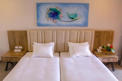 a bedroom with two beds and a painting on the wall at Pickalbatros Jungle Aqua Park - Neverland Hurghada in Hurghada