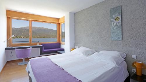 a bedroom with a bed and a desk and a window at Posada del Agua in El Barraco