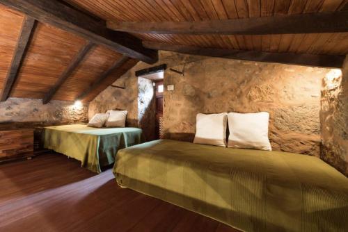 a bedroom with two beds in a room with wooden ceilings at Montsant in Teror