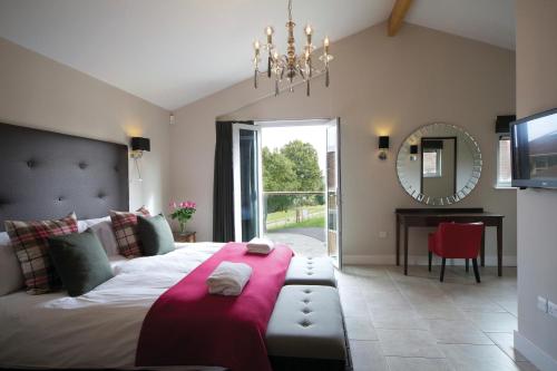 a bedroom with a large bed and a mirror at Apple Tree Lodges in Colchester