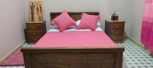 een slaapkamer met een bed met roze lakens en roze kussens bij Villa Chouiter Center in Marrakesh