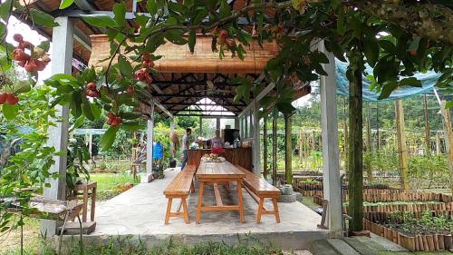 a wooden table in a pavilion in a garden at Vườn Nhà Ngoại Garden Homestay in Cu Chi