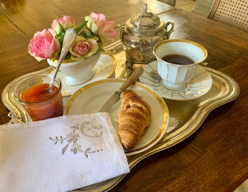 une table avec une assiette de pain et une tasse de café dans l'établissement Logis de La Touche, à Saint-Hilaire-des-Loges
