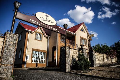 un bâtiment avec une clôture devant lui dans l'établissement Churchill-Inn, à Vinnytsia