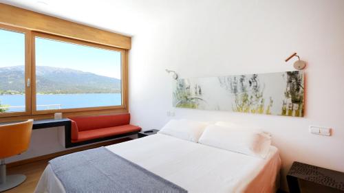 a bedroom with a bed and a large window at Posada del Agua in El Barraco