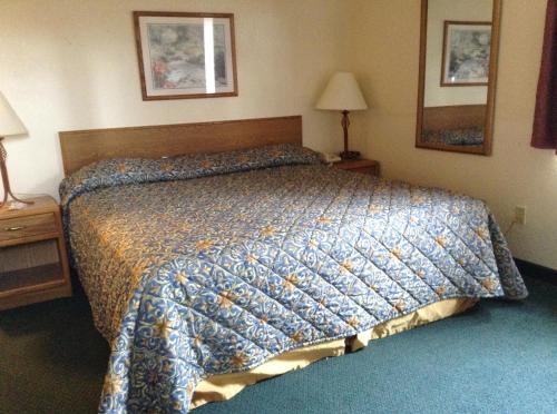a bedroom with a bed with a blue comforter at Travelodge by Wyndham Hudsonville in Hudsonville