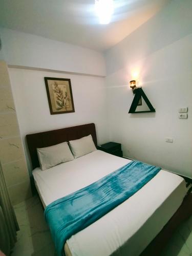 a bedroom with a bed with a blue blanket on it at Sababa Hotel Apartments in Dahab