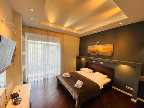 a bedroom with a bed with a fireplace and a tv at Real Home Apartments in Kiev Center in Kyiv