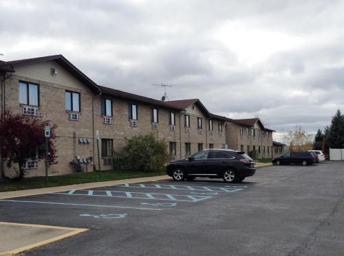 a car parked in a parking lot in front of a building at Travelodge by Wyndham Hudsonville in Hudsonville