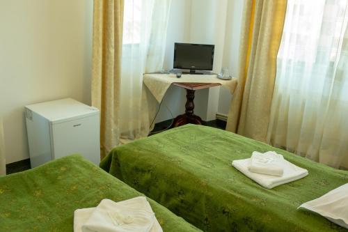 a room with two beds and a desk with a computer at Curtea Brancovenească in Constanţa