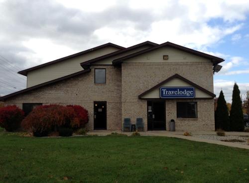 a building with a sign on the front of it at Travelodge by Wyndham Hudsonville in Hudsonville