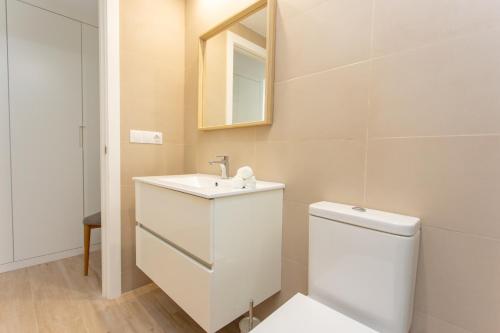 uma casa de banho com um WC, um lavatório e um espelho. em Denia apartment Marina em Denia