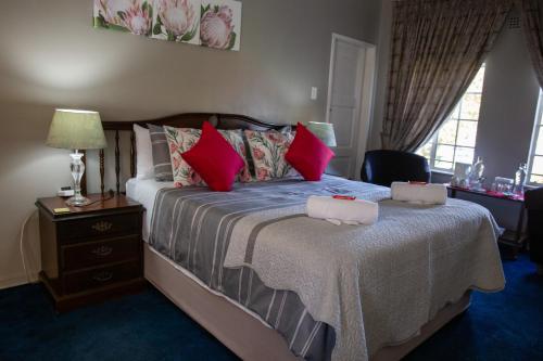 a bedroom with a large bed with red pillows at Ailani Blue Room in Benoni