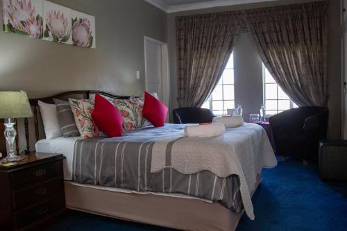 a bedroom with a large bed with red pillows at Ailani Blue Room in Benoni
