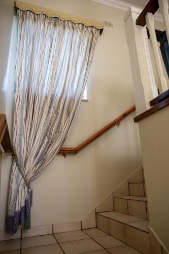 a stairway with a window and a curtain at Ailani Blue Room in Benoni