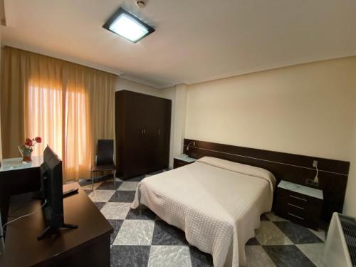 a hotel room with a bed and a television at Hotel godisa in Argamasilla de Calatrava