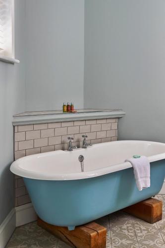 a blue bath tub sitting in a bathroom at Hotel du Vin Winchester in Winchester
