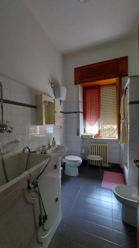 a bathroom with two sinks and a tub and a toilet at Casa Clelia in Teramo