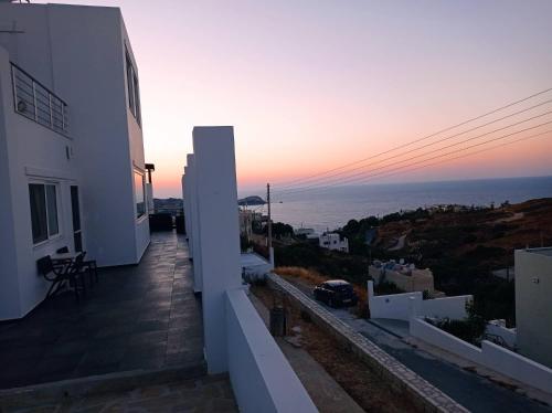 a sunset from the balcony of a white building at Villa Casa del mar in Lygaria